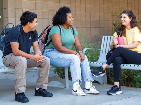 3 college students chatting on benches outside the SALT Center